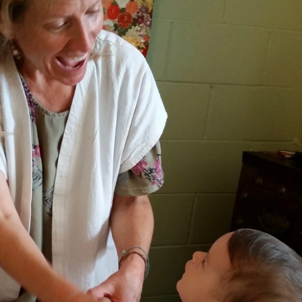Dr Sally smiling and interacting with a child